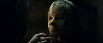Movie still from “Pinocchio” (2019), directed by Matteo Garrone – A person with a wooden mask on their face; Close Up shot, Low angle