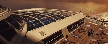 Movie still from “Poseidon” (2006), directed by Wolfgang Petersen – An aerial view of a large building on the deck of a ship; Extreme Wide shot, Overhead angle