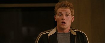 Movie still from “Poseidon” (2006), directed by Wolfgang Petersen – A man with spiky hair is looking surprised; Close Up shot, Over the shoulder angle