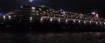 Movie still from “Poseidon” (2006), directed by Wolfgang Petersen – A large ship is lit up at night in the water; Extreme Wide shot, High angle
