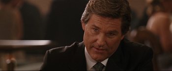 Movie still from “Poseidon” (2006), directed by Wolfgang Petersen – A person wearing a suit and tie; Close Up shot, Over the shoulder angle