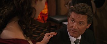 Movie still from “Poseidon” (2006), directed by Wolfgang Petersen – A man in a suit and tie sitting next to a woman in a black dress; Close Up shot, Over the shoulder angle