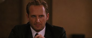 Movie still from “Poseidon” (2006), directed by Wolfgang Petersen – A man in a black suit and white tie; Close Up shot, Over the shoulder angle