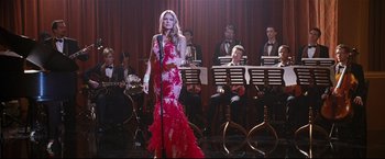 Movie still from “Poseidon” (2006), directed by Wolfgang Petersen – A woman in a red dress singing in front of a band; Wide shot, Low angle