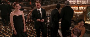 Movie still from “Poseidon” (2006), directed by Wolfgang Petersen – A man in a black suit and a white shirt is holding a cell phone; Medium shot, Over the shoulder angle
