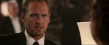 Movie still from “Poseidon” (2006), directed by Wolfgang Petersen – A man in a suit and tie looking at the camera; Close Up shot, Over the shoulder angle