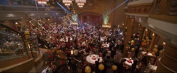 Movie still from “Poseidon” (2006), directed by Wolfgang Petersen – A crowd of people sitting at tables in front of a stage; Extreme Wide shot, High angle