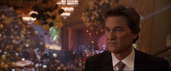 Movie still from “Poseidon” (2006), directed by Wolfgang Petersen – A person wearing a suit and tie; Close Up shot, Over the shoulder angle