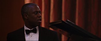 Movie still from “Poseidon” (2006), directed by Wolfgang Petersen – A man wearing a tuxedo and a bow tie; Close Up shot, Over the shoulder angle