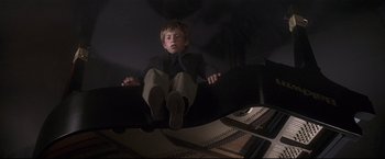 Movie still from “Poseidon” (2006), directed by Wolfgang Petersen – A boy sitting on top of a grand piano; Wide shot, High angle