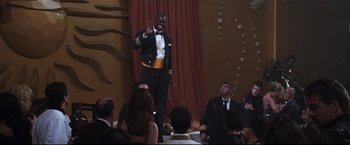 Movie still from “Poseidon” (2006), directed by Wolfgang Petersen – A man standing in front of a group of people; Medium shot, Over the shoulder angle