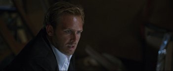 Movie still from “Poseidon” (2006), directed by Wolfgang Petersen – A person wearing a suit and tie; Close Up shot, Over the shoulder angle