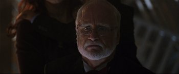 Movie still from “Poseidon” (2006), directed by Wolfgang Petersen – An older man with a beard and glasses; Close Up shot, Over the shoulder angle
