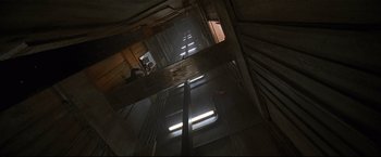 Movie still from “Poseidon” (2006), directed by Wolfgang Petersen – Looking down at a building with a light shining on it; Extreme Wide shot, Overhead angle