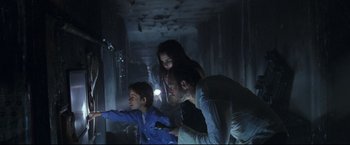 Movie still from “Poseidon” (2006), directed by Wolfgang Petersen – A group of people standing in a dark room; Medium shot, Low angle