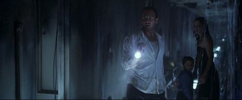 Movie still from “Poseidon” (2006), directed by Wolfgang Petersen – A man holding a flashlight while standing next to a wall; Medium shot, Low angle