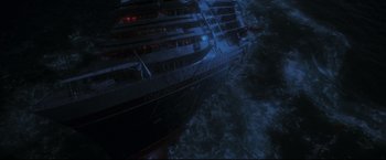 Movie still from “Poseidon” (2006), directed by Wolfgang Petersen – A large cruise ship in the middle of the ocean; Extreme Wide shot, Overhead angle