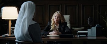 Movie still from “Prey for the Devil” (2022), directed by Daniel Stamm – A woman sitting at a table in front of another woman; Medium shot, Over the shoulder angle