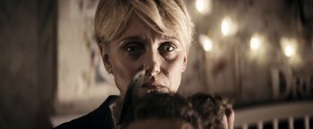 Movie still from “Prey for the Devil” (2022), directed by Daniel Stamm – A person with a knife in their mouth; Close Up shot, Over the shoulder angle