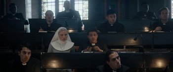 Movie still from “Prey for the Devil” (2022), directed by Daniel Stamm – A group of people sitting in a room; Medium shot, High angle