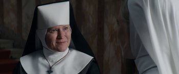 Movie still from “Prey for the Devil” (2022), directed by Daniel Stamm – An older woman wearing a nun's outfit; Close Up shot, Over the shoulder angle