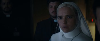 Movie still from “Prey for the Devil” (2022), directed by Daniel Stamm – A man and a woman standing next to each other in a room; Close Up shot, Over the shoulder angle