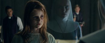 Movie still from “Prey for the Devil” (2022), directed by Daniel Stamm – A young girl in a white shirt and a woman in a white dress; Close Up shot, Over the shoulder angle