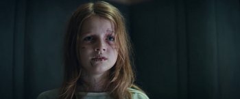 Movie still from “Prey for the Devil” (2022), directed by Daniel Stamm – A young girl with brown hair and a bruised face; Close Up shot, Low angle
