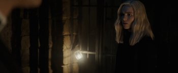 Movie still from “Prey for the Devil” (2022), directed by Daniel Stamm – A woman standing in a dark room with a light shining on her head; Close Up shot, Over the shoulder angle