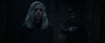 Movie still from “Prey for the Devil” (2022), directed by Daniel Stamm – Two people standing next to each other near a brick wall; Medium shot, Over the shoulder angle