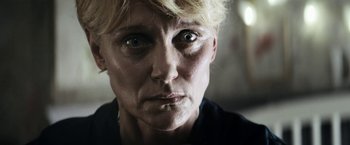 Movie still from “Prey for the Devil” (2022), directed by Daniel Stamm – A woman's face in a black shirt; Close Up shot, Low angle