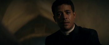 Movie still from “Prey for the Devil” (2022), directed by Daniel Stamm – A person wearing a suit and tie; Close Up shot, Low angle