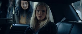 Movie still from “Prey for the Devil” (2022), directed by Daniel Stamm – A woman sitting in the back seat of a car; Close Up shot, Over the shoulder angle
