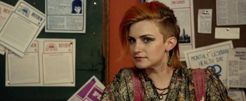 Movie still from “Pride” (2014), directed by Matthew Warchus – A woman with red hair and a shaved head; Close Up shot, Over the shoulder angle
