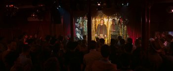 Movie still from “Pride” (2014), directed by Matthew Warchus – A group of people standing in front of an audience; Wide shot, Over the shoulder angle