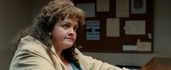 Movie still from “Pride” (2014), directed by Matthew Warchus – A woman sitting in front of a bulletin board; Close Up shot, Over the shoulder angle