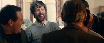 Movie still from “Pride” (2014), directed by Matthew Warchus – A man with a beard is talking to another man; Medium shot, Over the shoulder angle