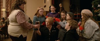 Movie still from “Pride” (2014), directed by Matthew Warchus – A group of people standing around a man; Medium shot, Over the shoulder angle