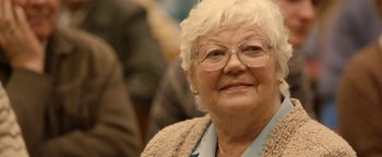 Movie still from “Pride” (2014), directed by Matthew Warchus – An older woman wearing glasses and a sweater; Close Up shot, Over the shoulder angle
