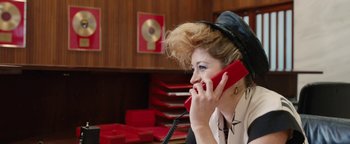 Movie still from “Pride” (2014), directed by Matthew Warchus – A woman talking on a phone while wearing a hat; Close Up shot, Over the shoulder angle