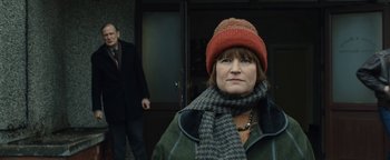 Movie still from “Pride” (2014), directed by Matthew Warchus – A woman wearing a red hat and a scarf standing in front of a man; Close Up shot, Low angle