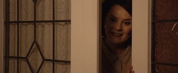 Movie still from “Pride” (2014), directed by Matthew Warchus – A person in a mirror smiling; Close Up shot, Over the shoulder angle