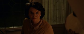 Movie still from “Pride” (2014), directed by Matthew Warchus – A woman in a brown jacket is smiling for the camera; Close Up shot, Over the shoulder angle