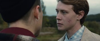 Movie still from “Pride” (2014), directed by Matthew Warchus – Two people are looking at each other in a field; Close Up shot, Over the shoulder angle