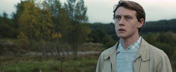 Movie still from “Pride” (2014), directed by Matthew Warchus – A man in a beige jacket is standing in a field; Close Up shot, Over the shoulder angle