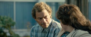 Movie still from “Pride” (2014), directed by Matthew Warchus – An older man with curly brown hair and a checkered shirt; Close Up shot, Over the shoulder angle