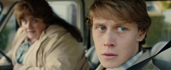 Movie still from “Pride” (2014), directed by Matthew Warchus – A person with a cat in the background; Close Up shot, Over the shoulder angle