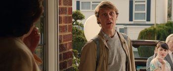 Movie still from “Pride” (2014), directed by Matthew Warchus – A man standing in front of a window; Medium shot, Over the shoulder angle
