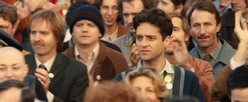 Movie still from “Pride” (2014), directed by Matthew Warchus – A crowd of people standing in a room; Close Up shot, Over the shoulder angle