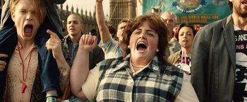 Movie still from “Pride” (2014), directed by Matthew Warchus – A woman with her mouth wide open and her hand raised in the air; Medium shot, Low angle
